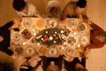 Holiday table set with feast and 8 people ready to eat